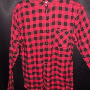 Medium sized button up with a red and black plaid design.